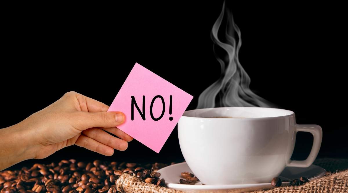 Tazzina di caffè fumante su un tavolo di legno, simbolo di una routine mattutina potenzialmente irritante per chi soffre di reflusso gastrico