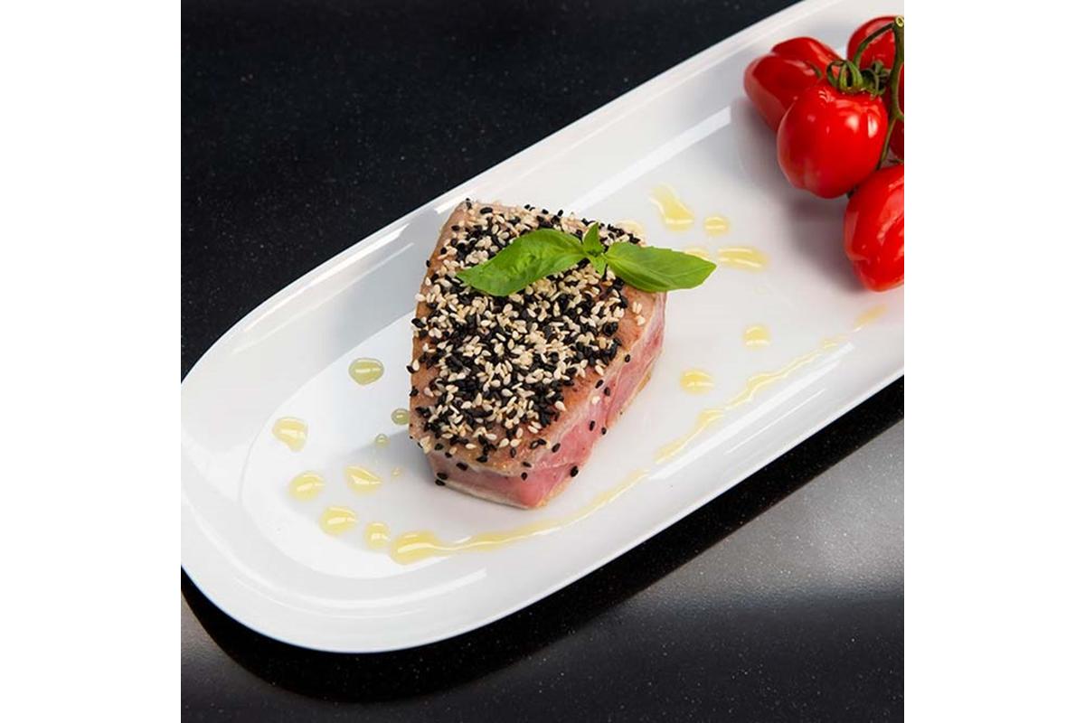 "Filetto di tonno rosa, succoso e tenero, cotto a bassa temperatura su piatto elegante."