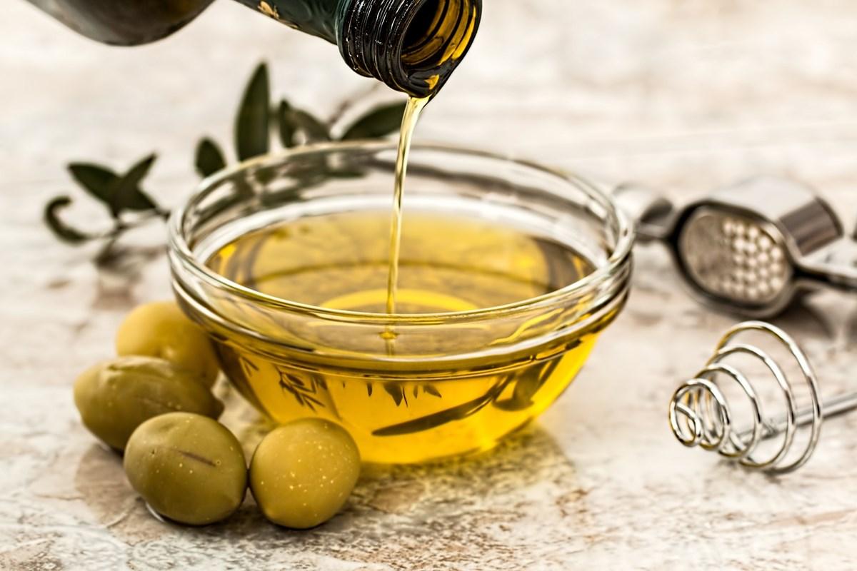 Bottiglie di olio d'oliva sugli scaffali del supermercato, alcune con etichette poco trasparenti.