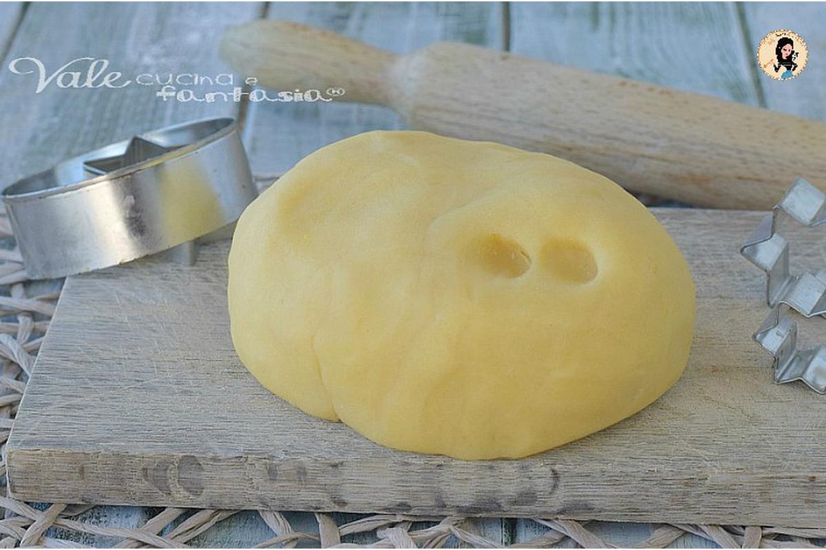 Un pasticcere esperto prepara pasta frolla dorata per una crostata irresistibile su un tavolo infarinato.
